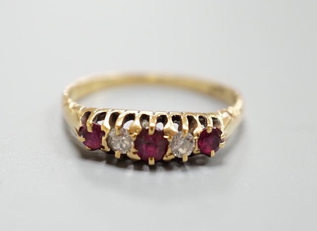 An 18ct three stone ruby and two stone diamond set half hoop ring, size P, gross 2.9 grams.